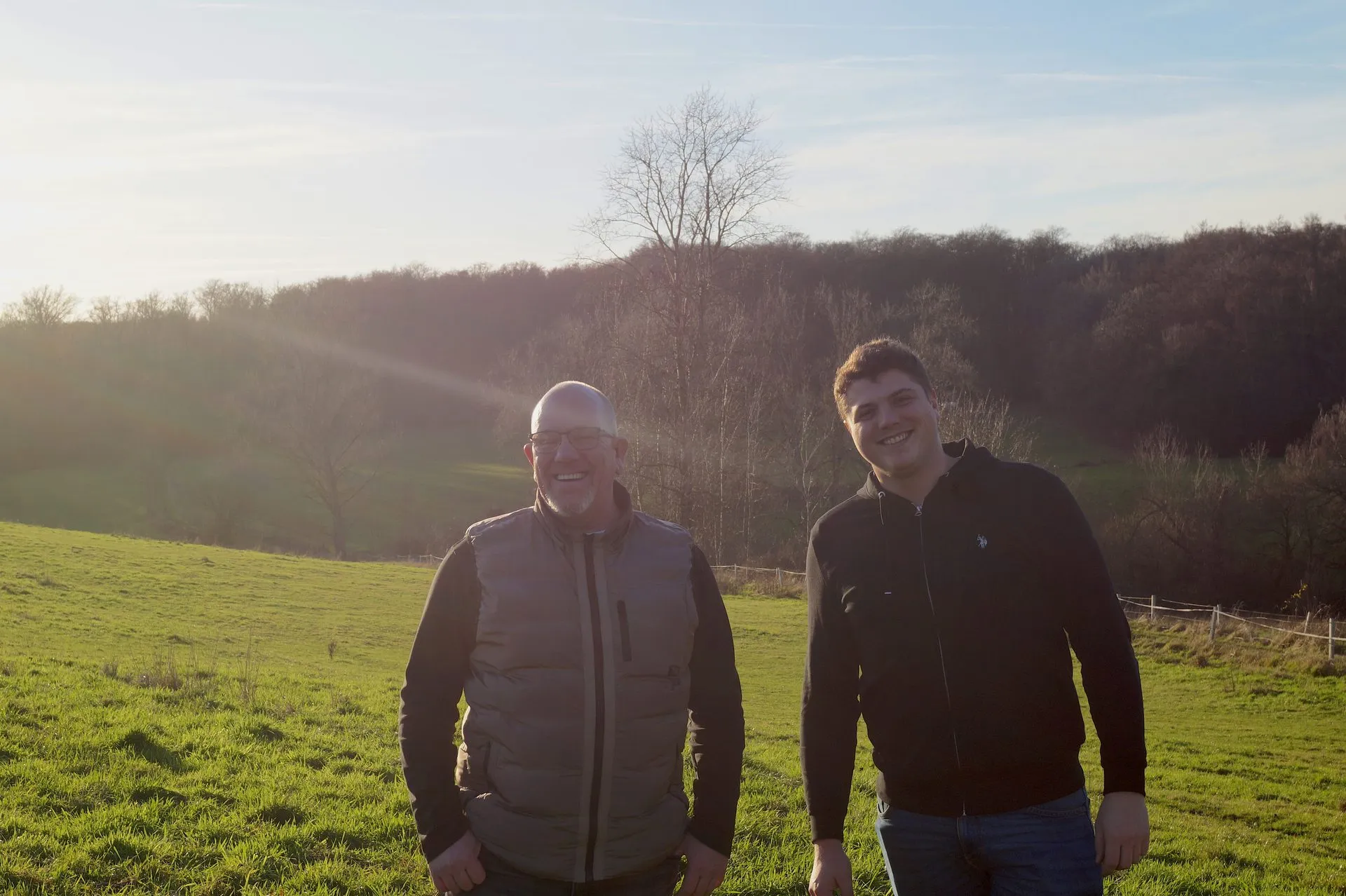 Frank und Tim, die Gründer von Alltagsheroes, draußen im Feld bei goldenem Licht