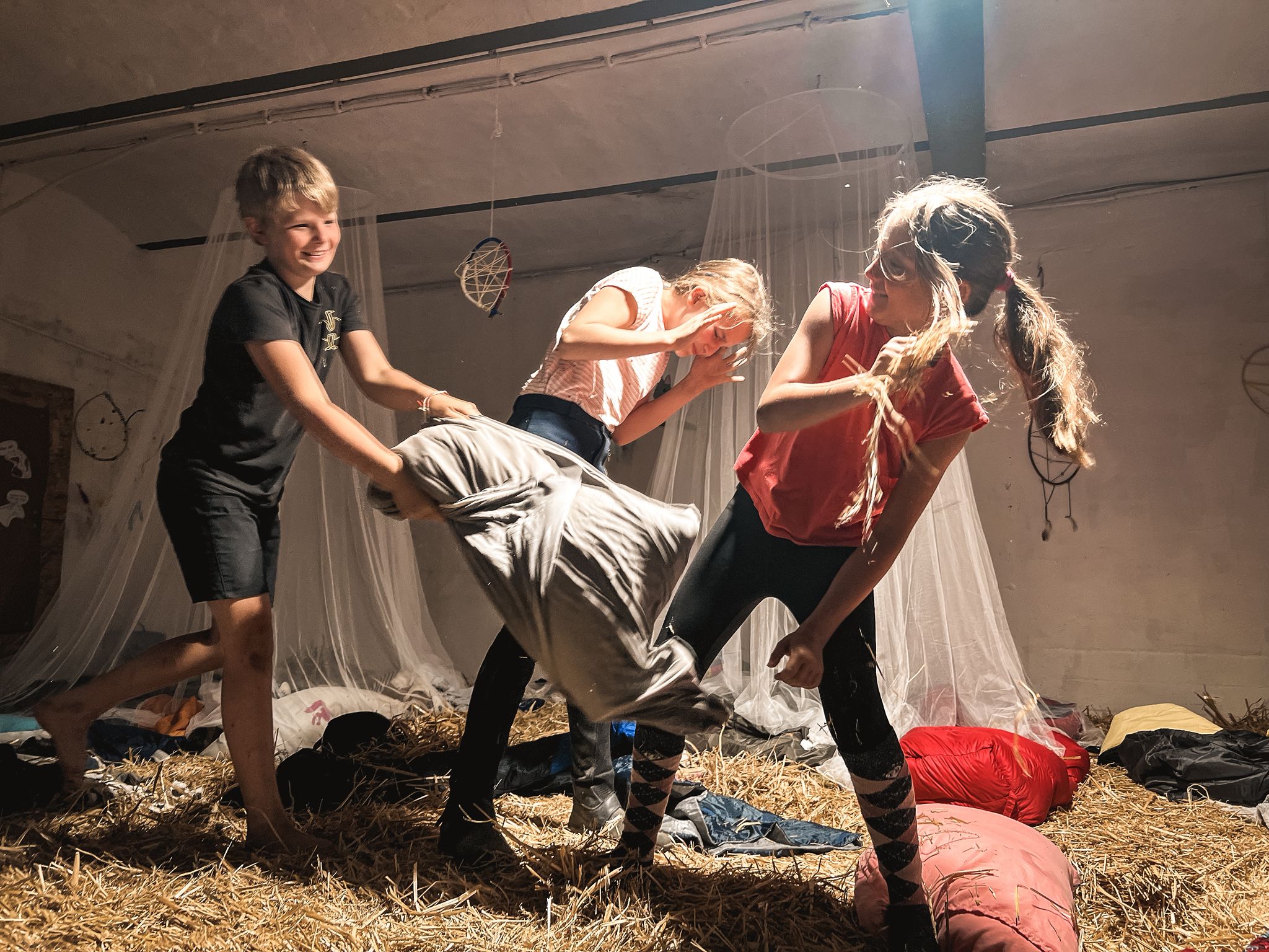 Kinder beim Kissenschlacht-Spielen im Stall